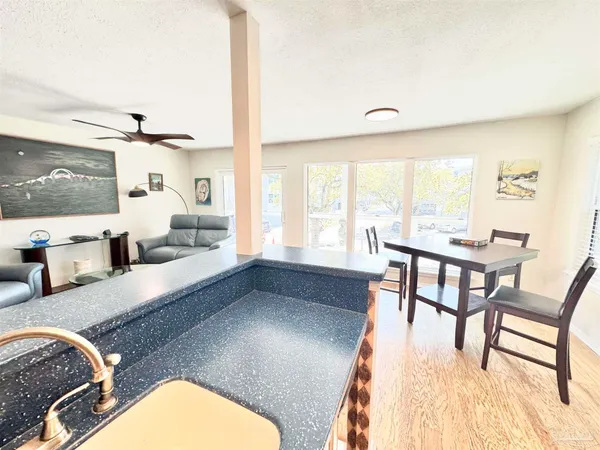 a living room with granite countertop furniture a rug potted plant and a large window