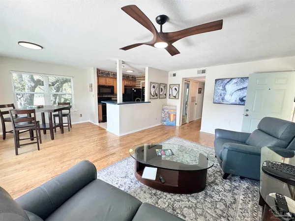 a living room with furniture and view of kitchen