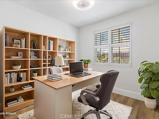 a bedroom with a bed a chair and a large window