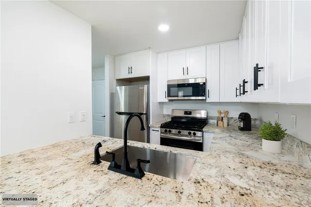 a kitchen with a sink a stove and cabinets