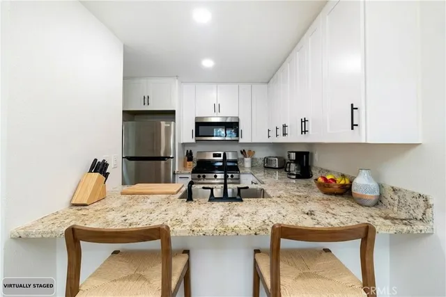 a kitchen with granite countertop a sink stove and cabinets