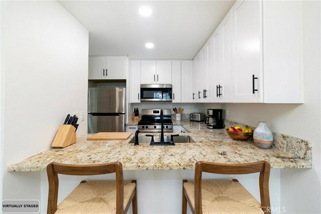 450 East 4th Street, Unit 237 Santa Ana, CA 92701 - Photo 2 of 25 a kitchen with granite countertop a sink stove and cabinets