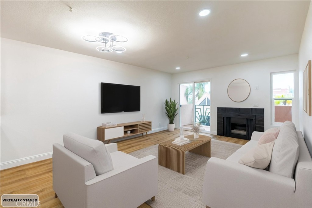 450 East 4th Street, Unit 237 Santa Ana, CA 92701 - Photo 4 of 25 a living room with furniture a fireplace and a flat screen tv