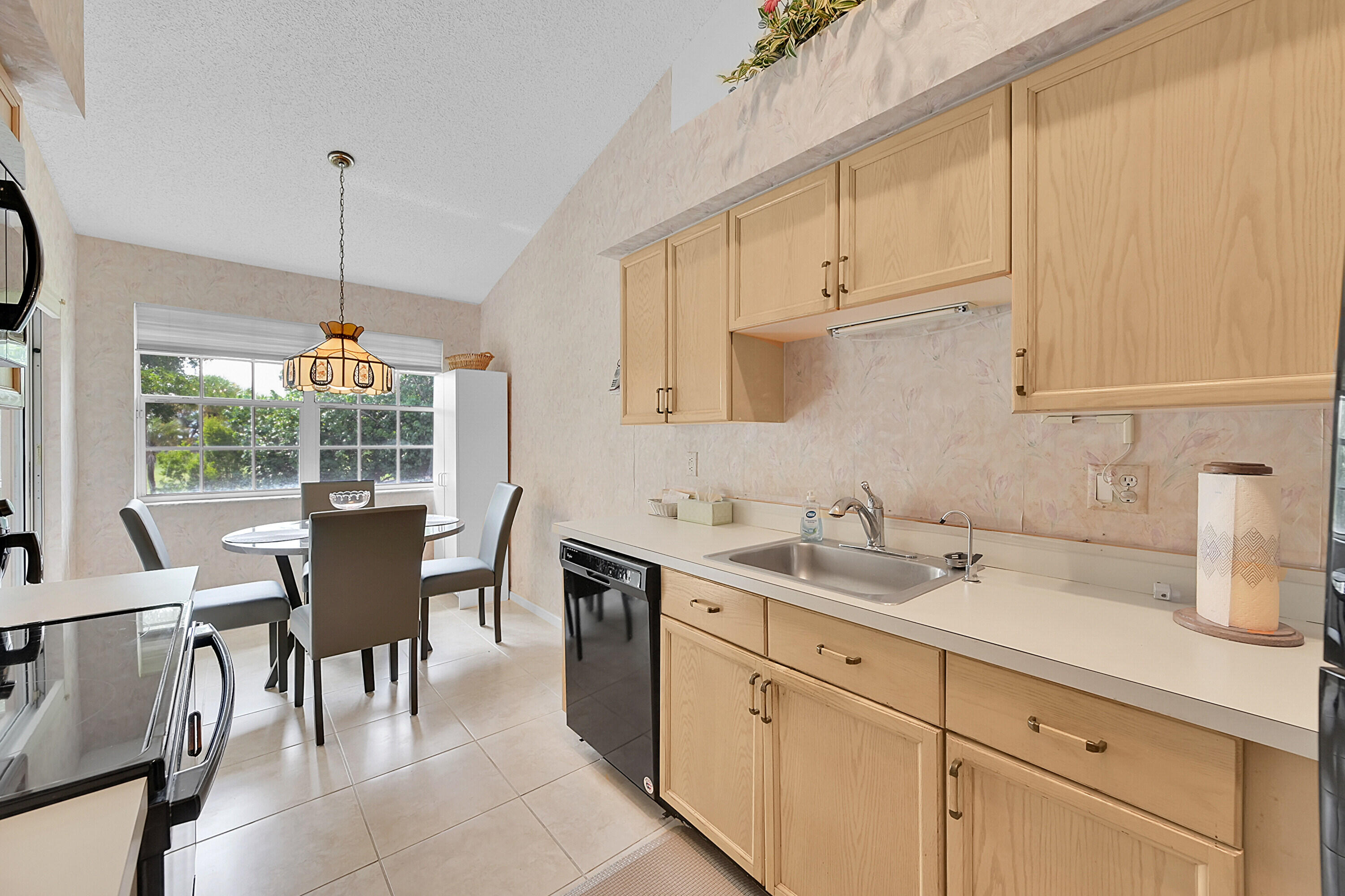 17270 Boca Club Boulevard, Unit 1702 Boca Raton, FL 33487 - Photo 13 of 41 a kitchen with a sink cabinets and dining table chair