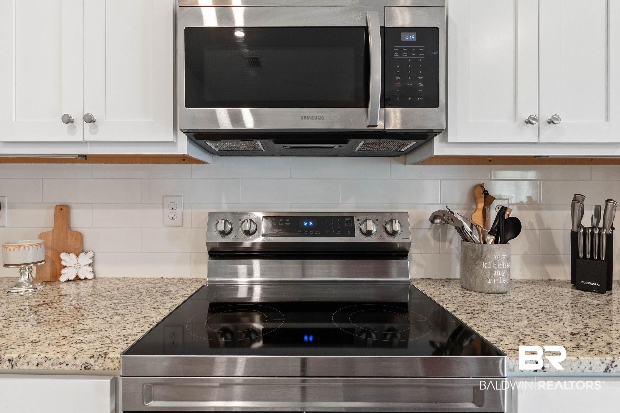 1203 Hayward Loop Foley, AL 36535 - Photo 12 of 41 Kitchen with stainless steel appliances, light stone counters, white cabinetry, and backsplash