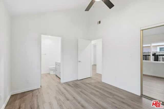a view of a room with wooden floor and a ceiling fan