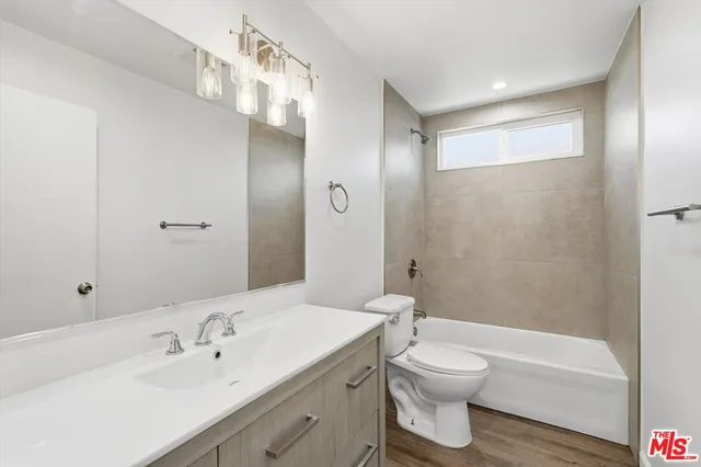 a bathroom with a double vanity sink toilet mirror and bathtub