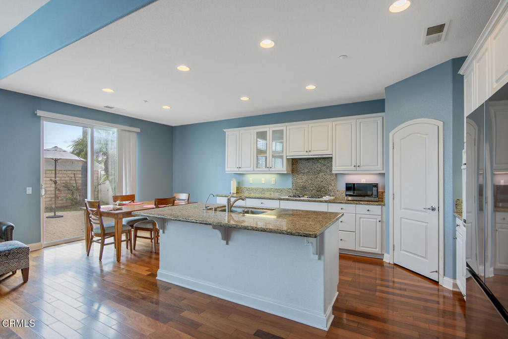 2920 Naples Drive Oxnard, CA 93035 - Photo 9 of 28 a kitchen with stainless steel appliances granite countertop wooden floors and wooden cabinets