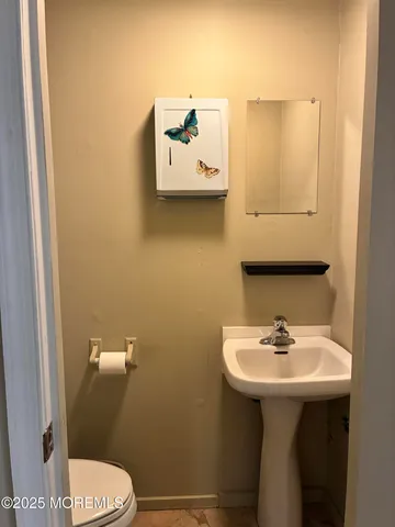 a bathroom with a sink mirror and toilet