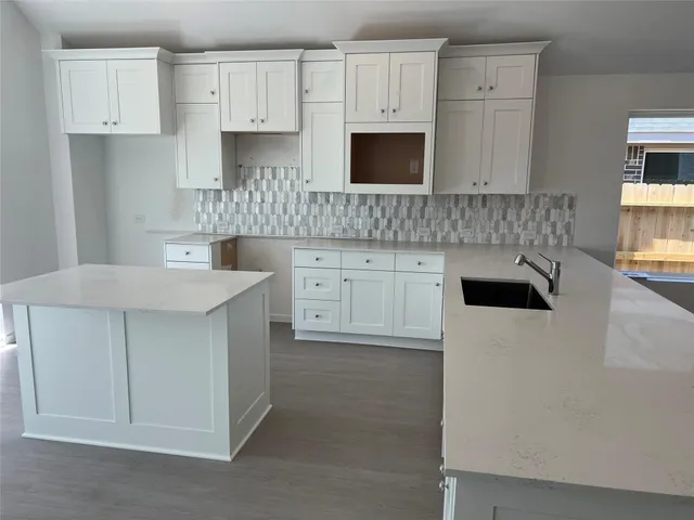 a kitchen with stainless steel appliances a sink a stove a microwave a sink and cabinets