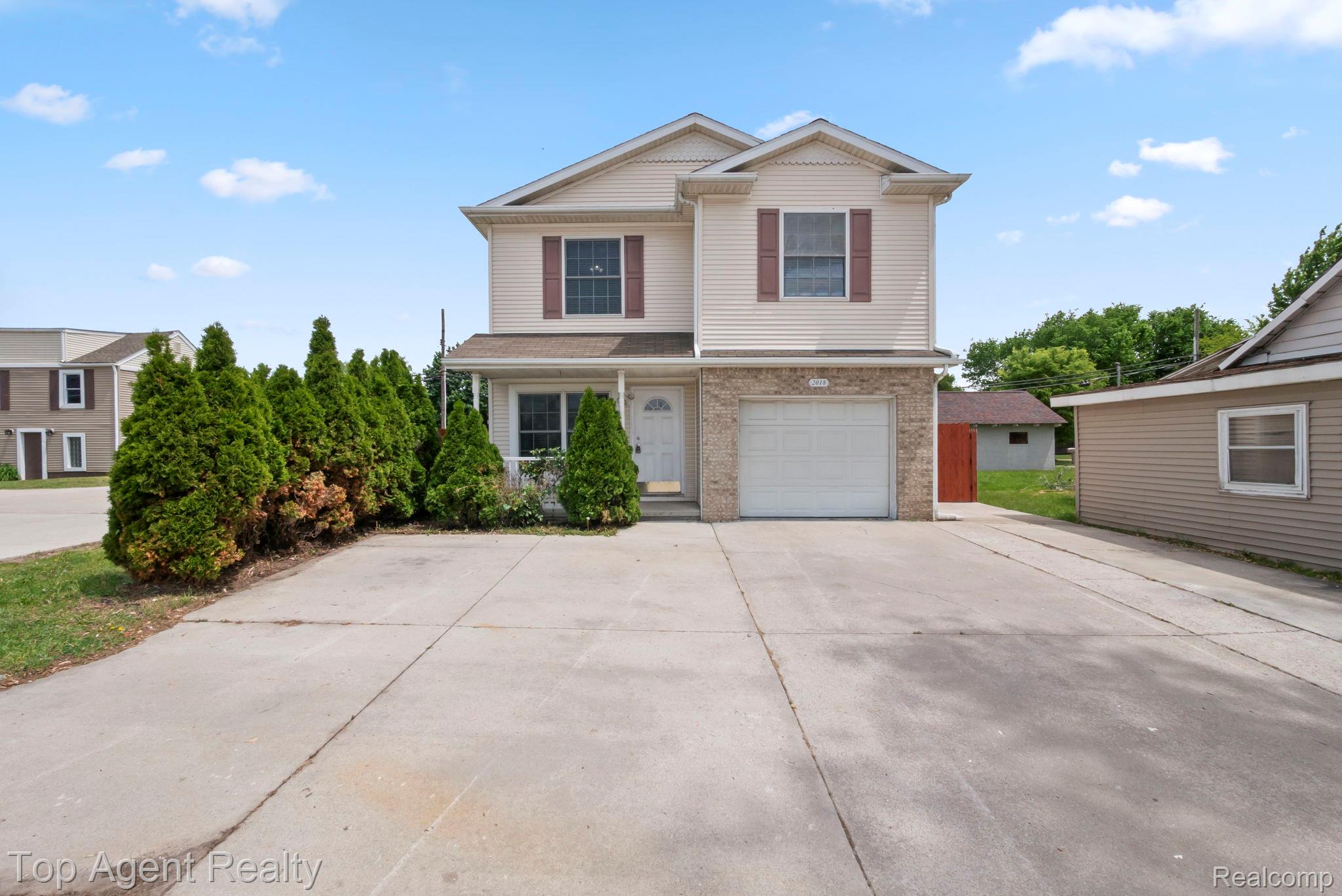 2018 John R Road Troy, MI 48083 - Photo 1 of 30 Traditional-style home featuring driveway, an attached garage, and brick siding