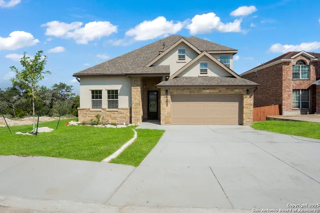 a front view of a house with a yard and garage