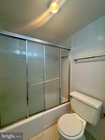 a white toilet sitting next to a bathroom sink and a shower