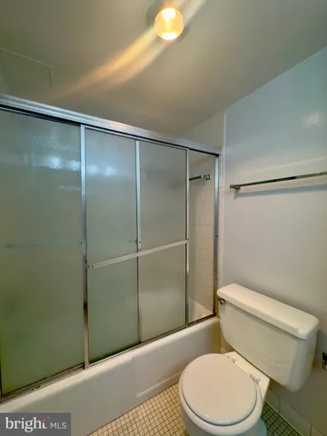 a white toilet sitting next to a bathroom sink and a shower