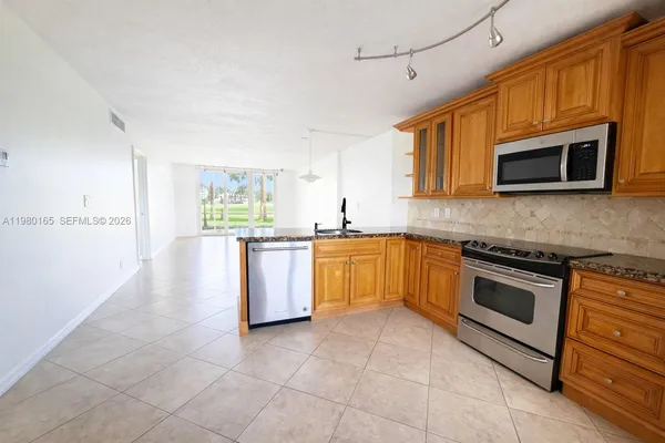 a kitchen with stainless steel appliances granite countertop a stove microwave and sink