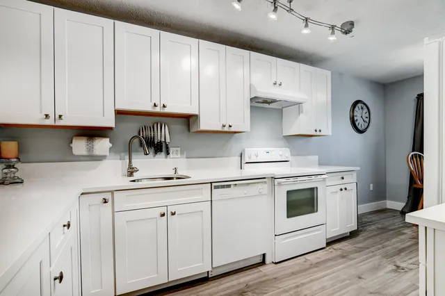 a kitchen with white cabinets and white appliances