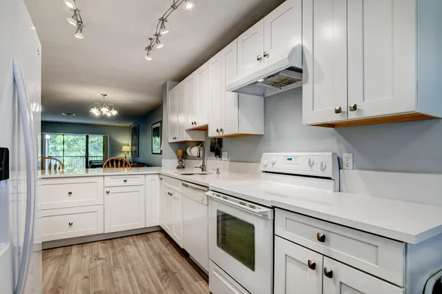 a kitchen with stainless steel appliances granite countertop a sink a stove and cabinets