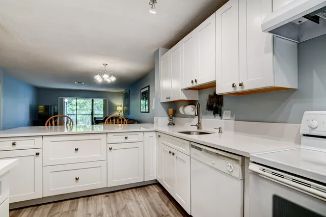a kitchen with granite countertop white cabinets and white appliances