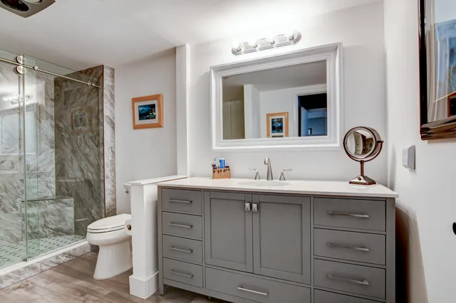 a bathroom with a toilet sink double vanity and mirror