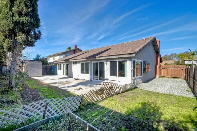 a view of backyard with small cabin and wooden fencing
