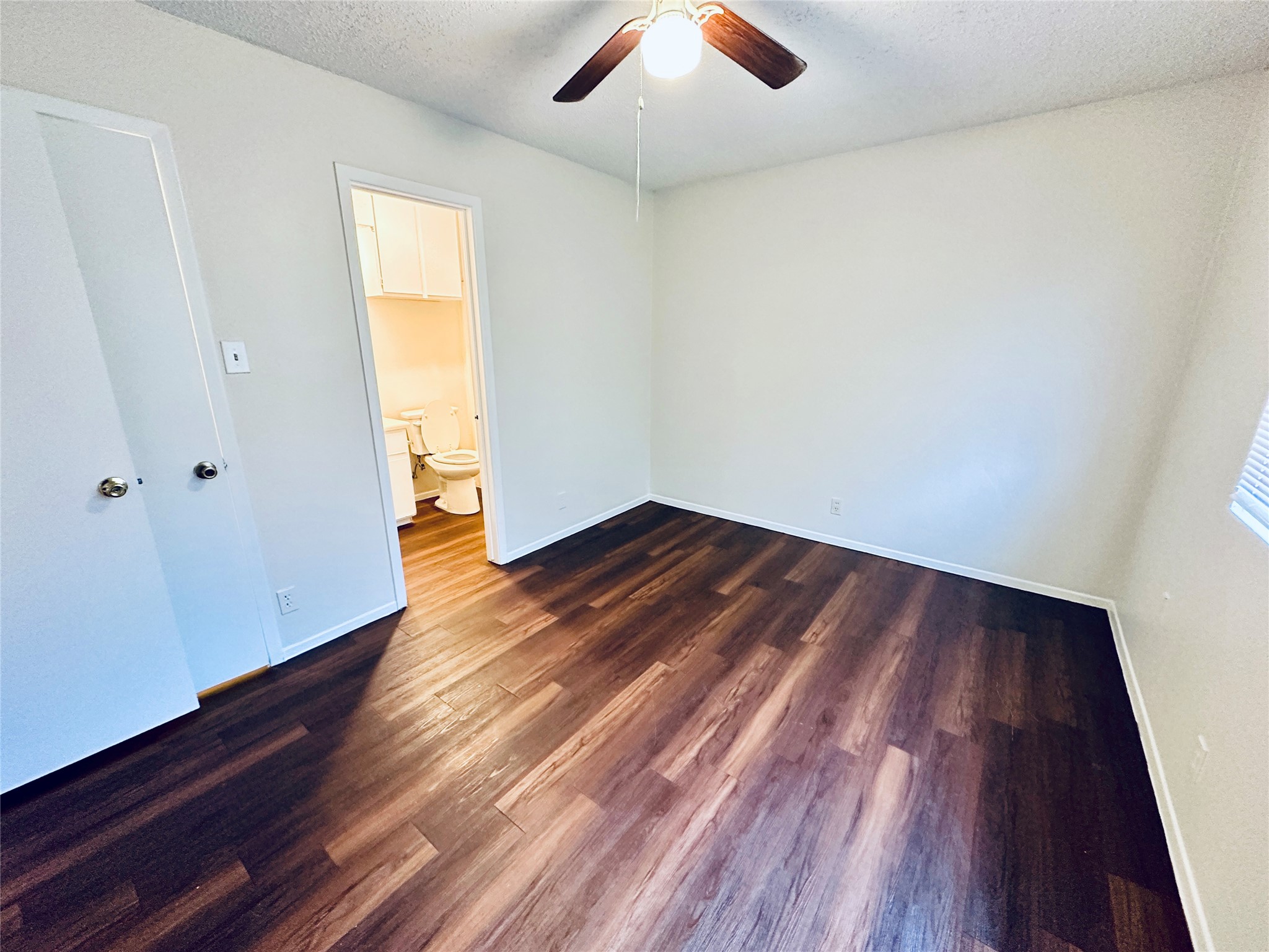 12505 Turtle Rock Road, Unit A Austin, TX 78729 - Photo 16 of 38 A comfortable bedroom with rich wood flooring offers a ceiling fan for climate control.