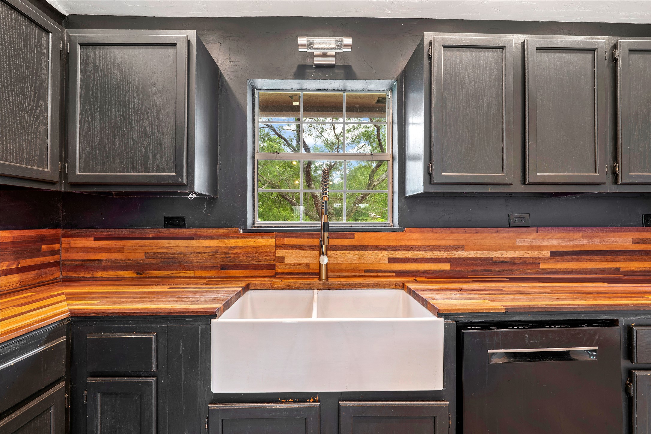 358 Easley Road Smithville, TX 78957 - Photo 12 of 36 Kitchen featuring butcher block countertops, a double basin sink and dark cabinetry
