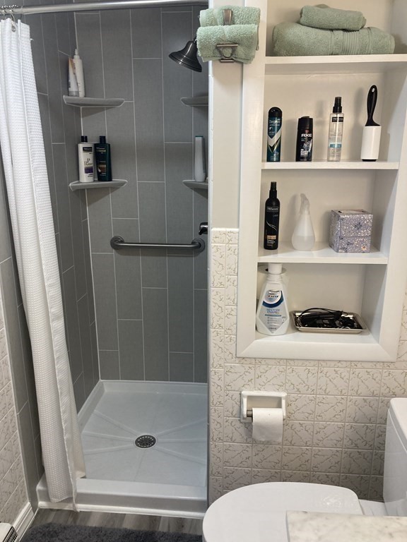 17 Adams Road Grafton, MA 01519 - Photo 27 of 42 a bathroom with a toilet and shower