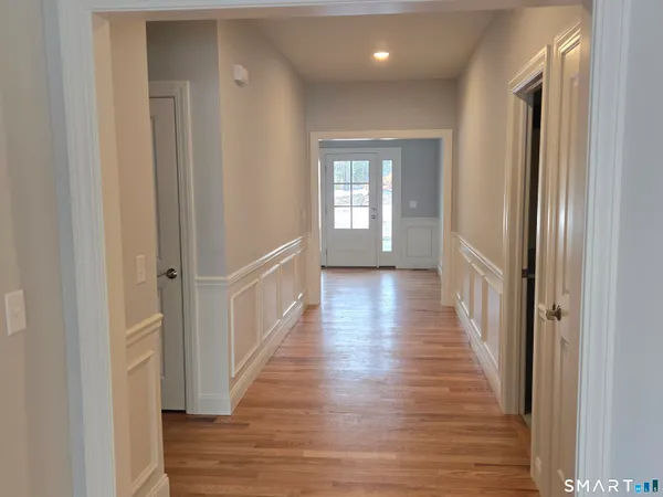 a view of an empty room with window and wooden floor