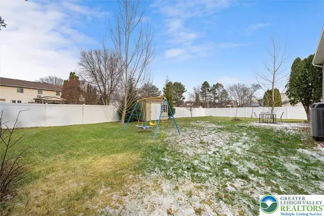 a view of yard with tree and a wooden fence