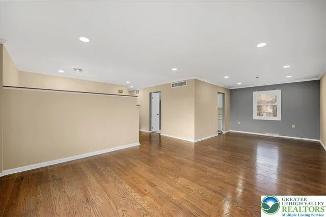 a view of an empty room with wooden floor