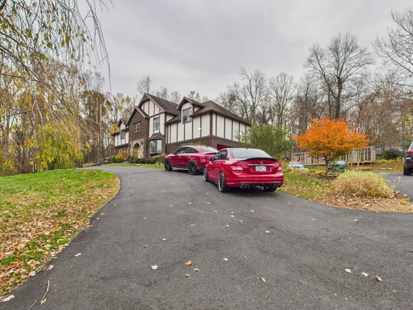 a car parked in front of a house next to a yard