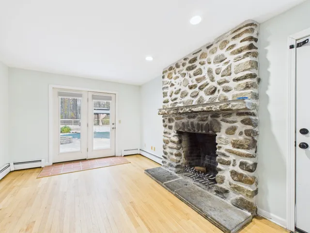 a view of an empty room with a fireplace and a window