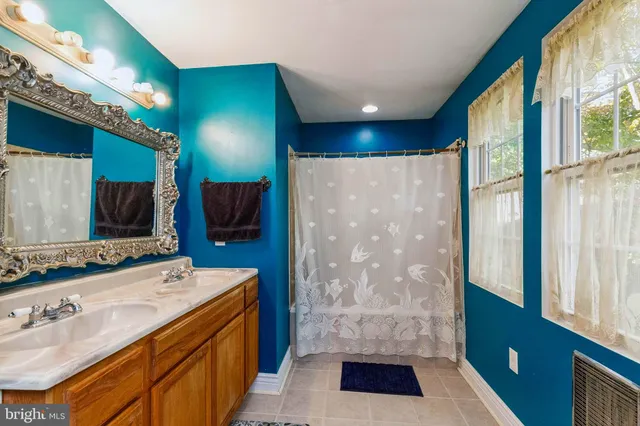 a spacious bathroom with a double vanity sink a mirror and a shower