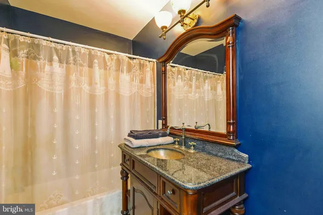 a bathroom with a granite countertop sink and a mirror