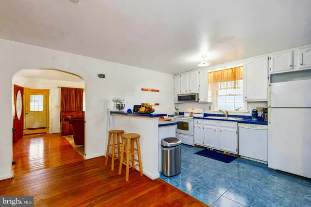 a kitchen with a refrigerator and white cabinets