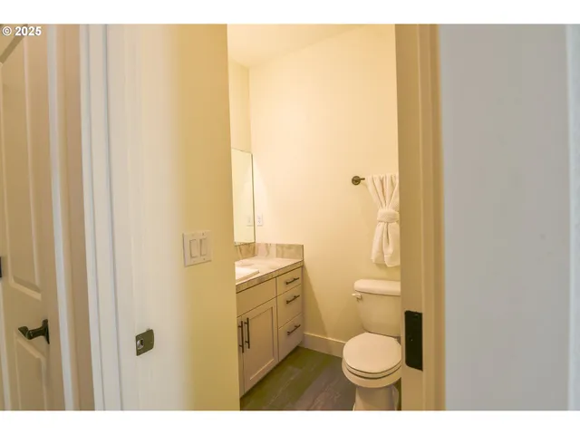 a bathroom with a granite countertop toilet and a sink