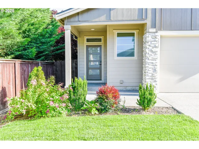 a view of a house with potted plants and a table and chair