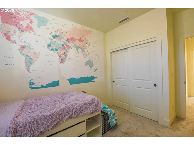 a bedroom with a bed and a painting on the wall