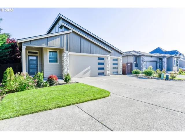a front view of a house with a yard and potted plants