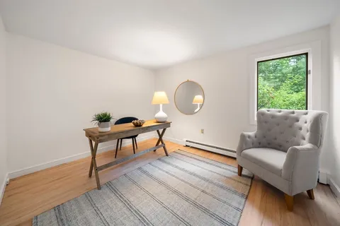 a living room with furniture a window and a potted plant