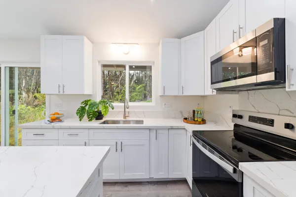 a kitchen with stainless steel appliances a stove microwave and sink