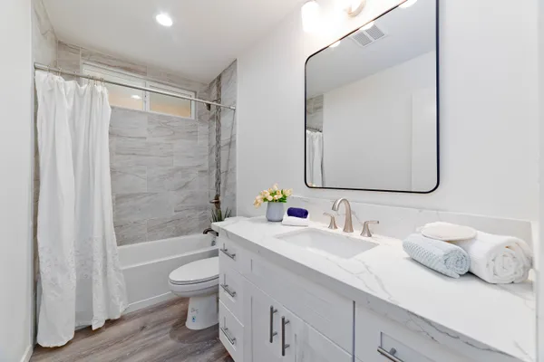 a bathroom with a double vanity sink toilet mirror and shower
