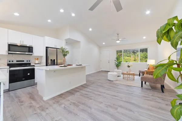a large white kitchen with stainless steel appliances