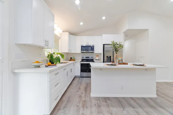 a kitchen with kitchen island granite countertop a sink counter top space and cabinets