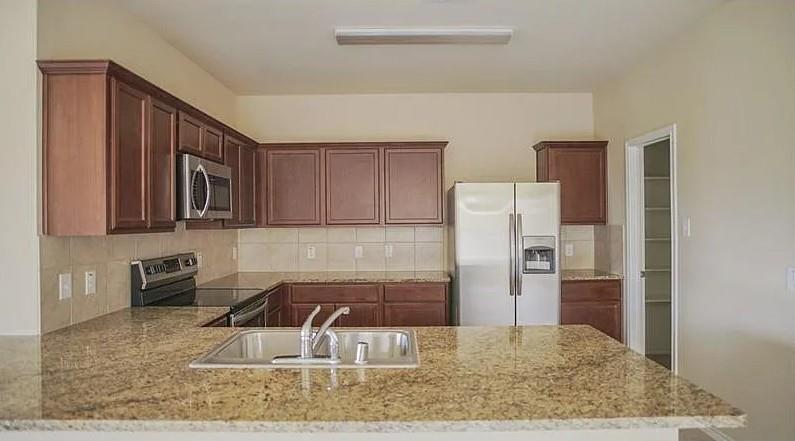 916 Opal Path Princeton, TX 75407 - Photo 2 of 9 a kitchen with stainless steel appliances granite countertop a refrigerator sink and stove