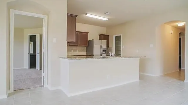 a view of kitchen with refrigerator and window