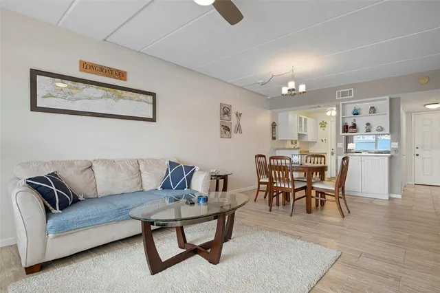a living room with furniture wooden floor and kitchen view