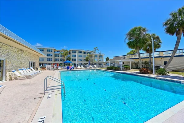 a view of a swimming pool with a patio and a yard