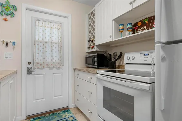 a kitchen with white cabinets and white appliances