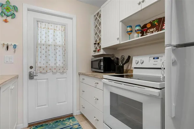 a kitchen with white cabinets and white appliances